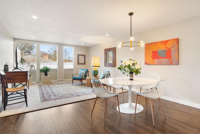 dining area with a chandelier, recessed lighting, wood-type flooring, and baseboards