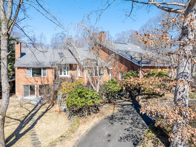 view of front of home with brick siding and a chimney