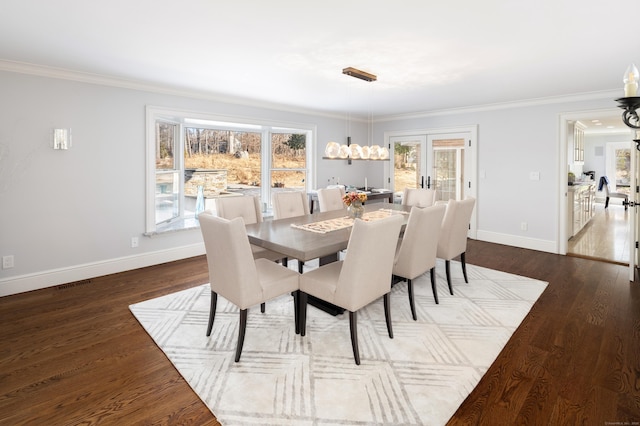 dining area with ornamental molding, dark wood-type flooring, visible vents, and baseboards