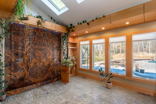 unfurnished sunroom featuring lofted ceiling with skylight and visible vents