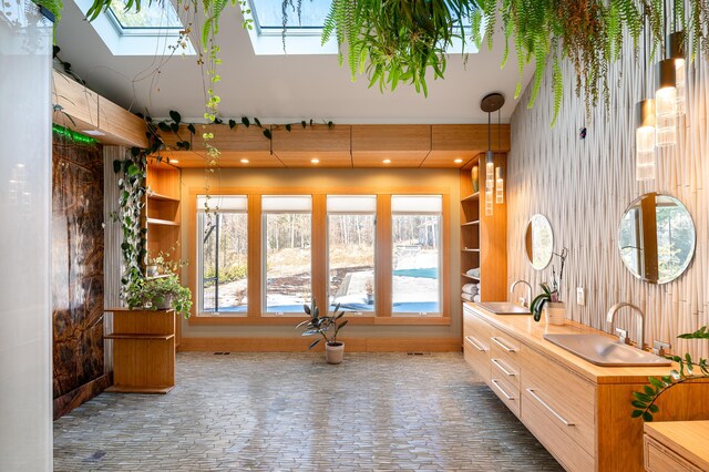 interior space featuring double vanity, a skylight, and a sink