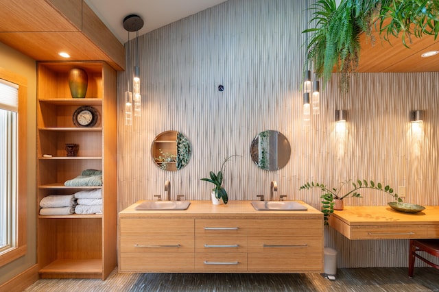 full bathroom featuring double vanity, built in shelves, and a sink