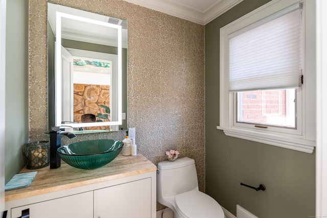 bathroom featuring a wealth of natural light, crown molding, vanity, and toilet