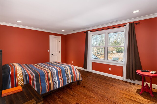 bedroom featuring baseboards, ornamental molding, and wood finished floors