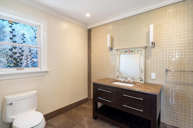 bathroom with toilet, vanity, tile walls, ornamental molding, and tile patterned floors