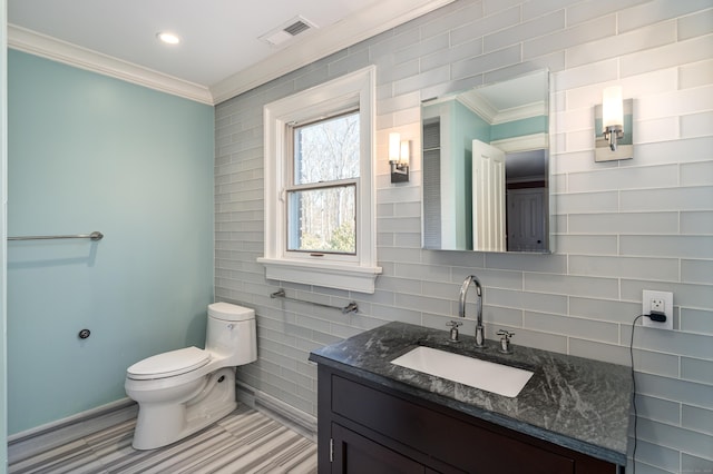 bathroom with toilet, vanity, visible vents, ornamental molding, and backsplash