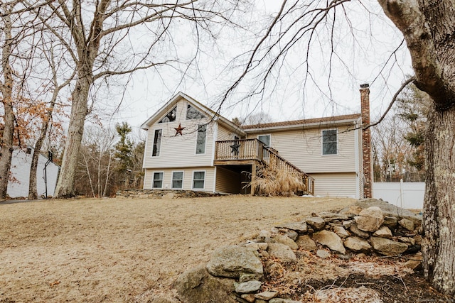 view of front facade featuring a deck, a chimney, and stairway