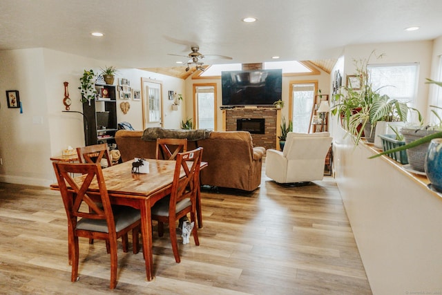 dining area with baseboards, a ceiling fan, light wood-style flooring, a fireplace, and recessed lighting