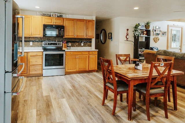 kitchen with recessed lighting, light wood-style floors, light countertops, appliances with stainless steel finishes, and tasteful backsplash