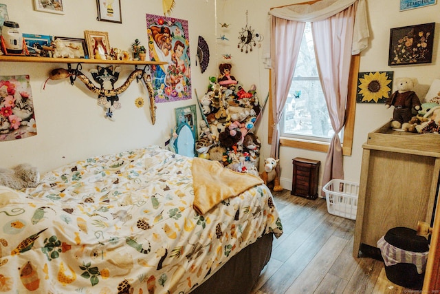 bedroom with wood-type flooring and baseboards