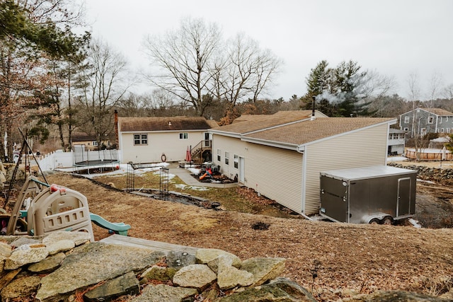 exterior space featuring a trampoline, a patio, and an outbuilding