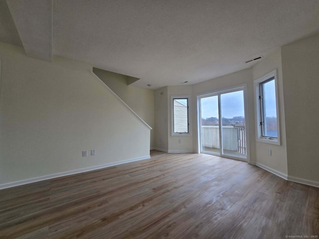 unfurnished room featuring visible vents, baseboards, and wood finished floors