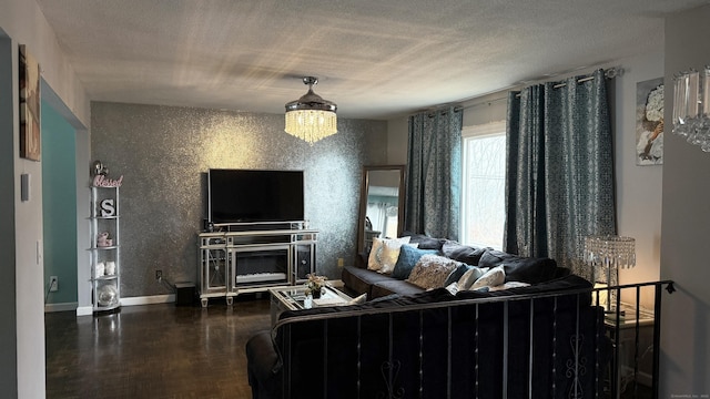 living area with an inviting chandelier, baseboards, and a textured ceiling