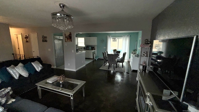 living area with baseboards and an inviting chandelier