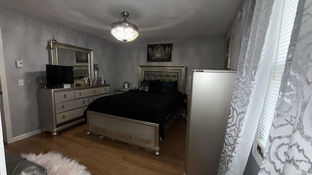 bedroom featuring wood finished floors and baseboards