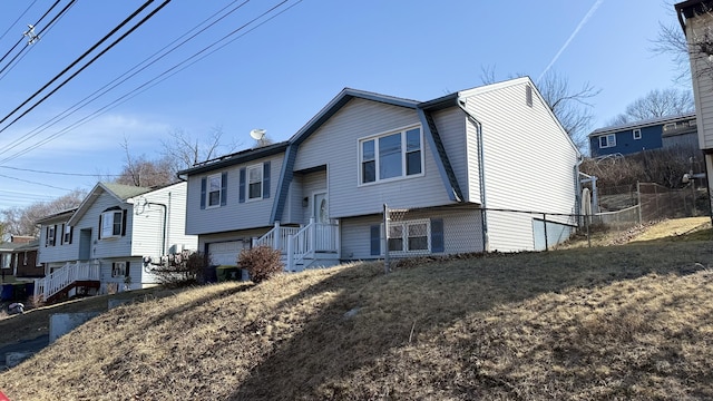 view of front of property featuring an attached garage and fence