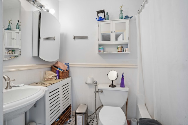 full bathroom featuring a wainscoted wall, a sink, and toilet