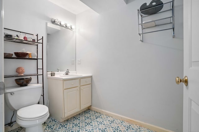 half bathroom featuring toilet, baseboards, and vanity