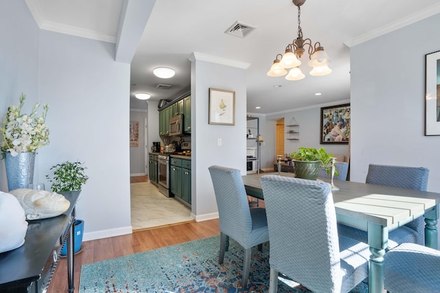 dining space with light wood finished floors, visible vents, and ornamental molding