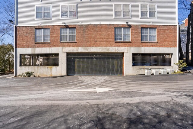 view of front of property with driveway and brick siding