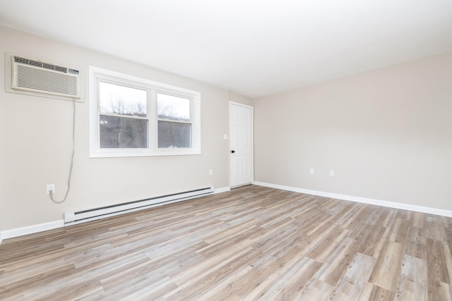 unfurnished room with an AC wall unit, light wood finished floors, baseboards, and baseboard heating