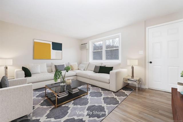 living room with a wall mounted air conditioner, baseboards, and wood finished floors