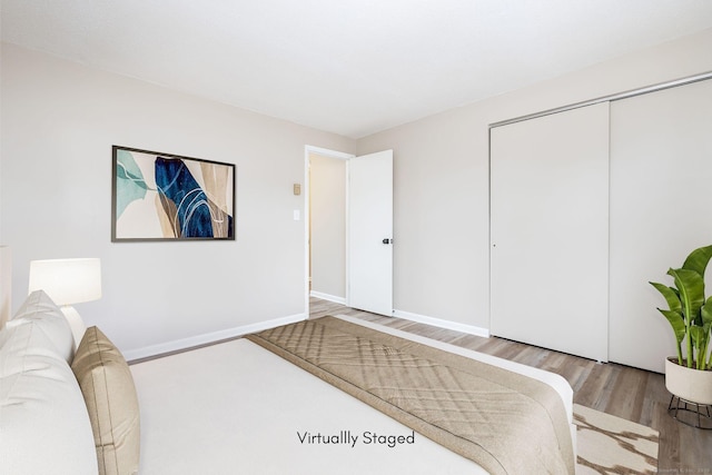 bedroom featuring a closet, baseboards, and wood finished floors