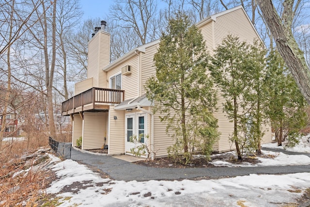 snow covered property with a chimney