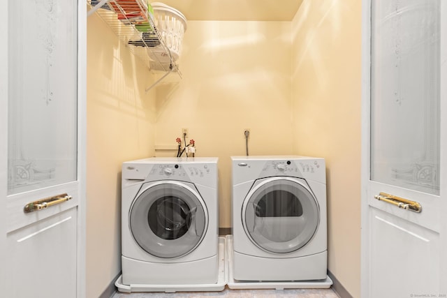 laundry area featuring laundry area, baseboards, and washer and clothes dryer