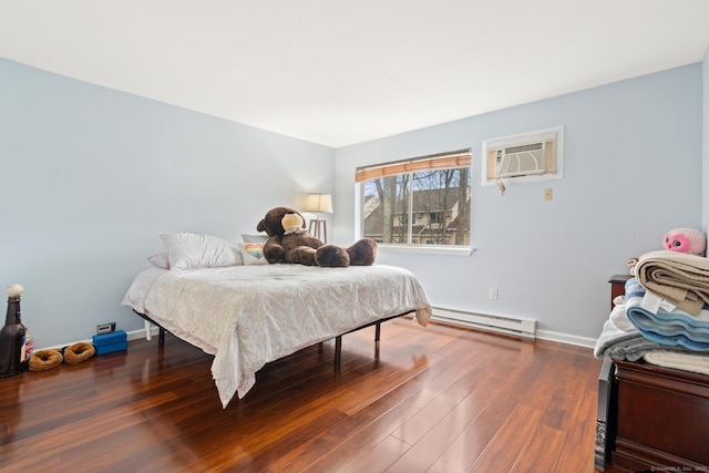 bedroom with baseboard heating, wood finished floors, a wall mounted AC, and baseboards