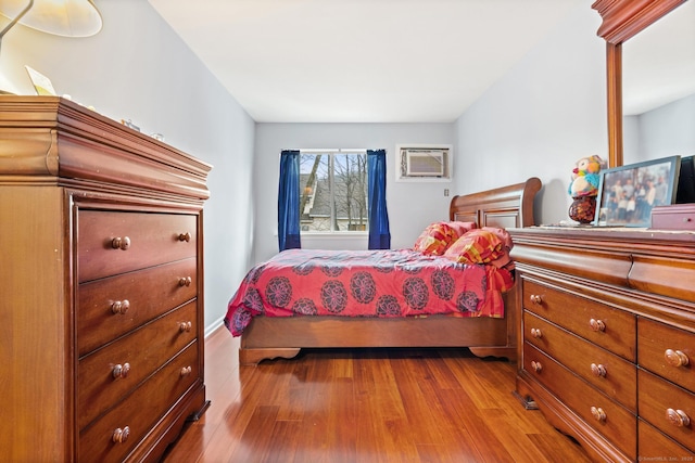 bedroom with dark wood-style floors and a wall mounted AC