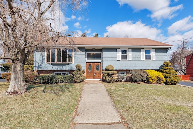 split foyer home with a front lawn and brick siding