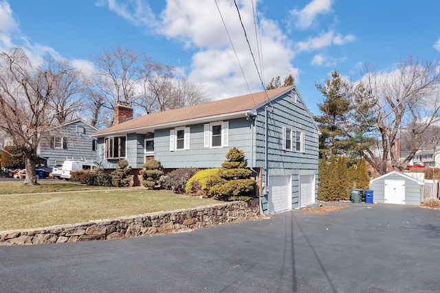 single story home featuring an attached garage, aphalt driveway, a chimney, and a front lawn