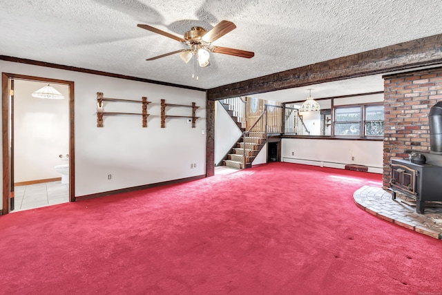 unfurnished living room with a textured ceiling, carpet flooring, stairway, baseboard heating, and a wood stove