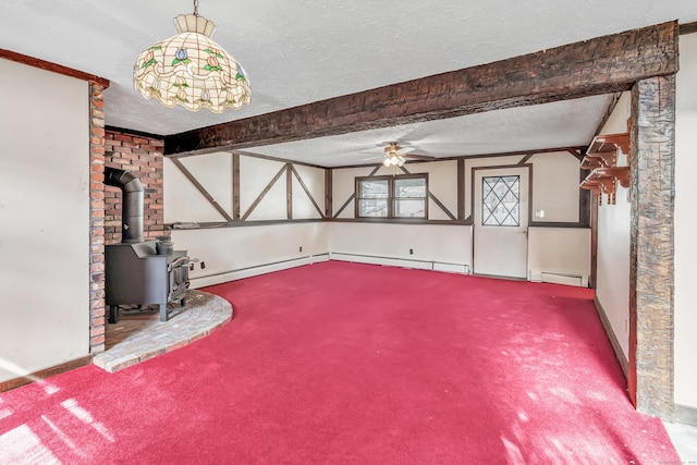 unfurnished living room featuring carpet floors, a baseboard heating unit, a wood stove, ceiling fan, and a textured ceiling