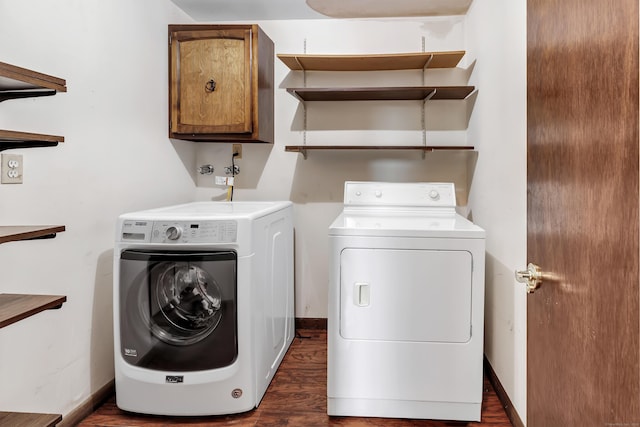 laundry area with dark wood-style flooring, washing machine and clothes dryer, cabinet space, and baseboards