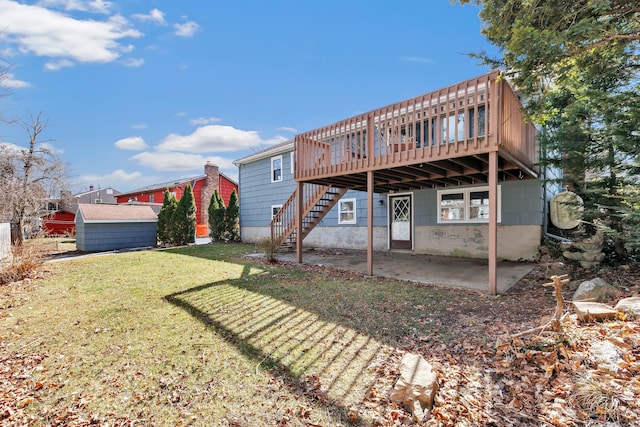 rear view of house with an outdoor structure, stairs, a yard, a wooden deck, and a patio area