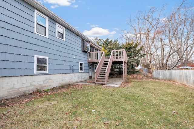 view of yard featuring fence, a wooden deck, and stairs