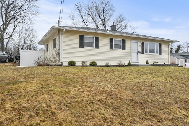 single story home with a chimney and a front lawn