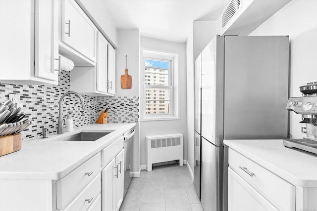 kitchen featuring a sink, visible vents, appliances with stainless steel finishes, backsplash, and radiator heating unit