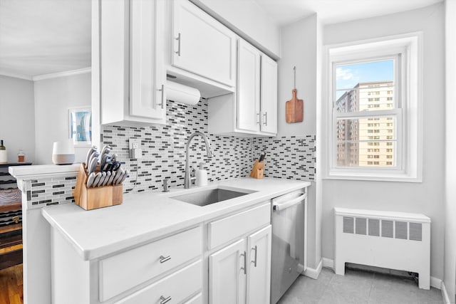 kitchen with radiator, stainless steel dishwasher, backsplash, and a sink