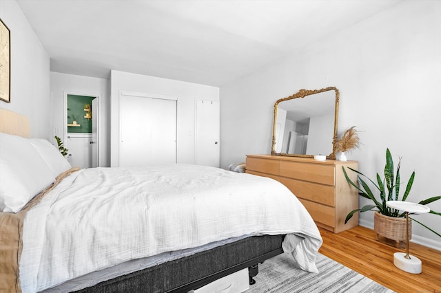 bedroom with light wood-style flooring and baseboards