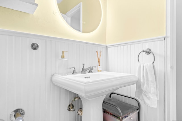 bathroom with a wainscoted wall and a sink