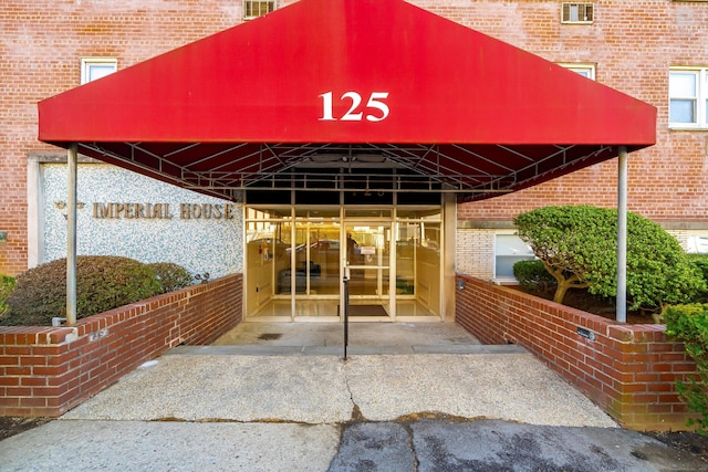 doorway to property featuring brick siding