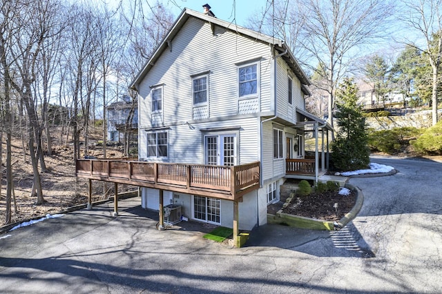 view of front of property featuring driveway, a deck, and central air condition unit