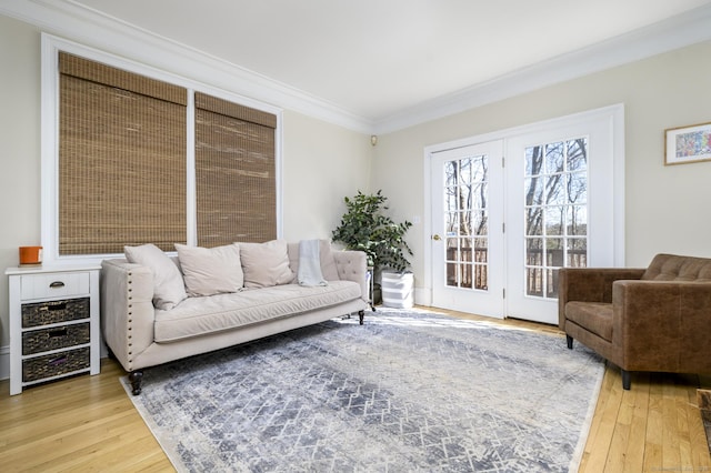 living area featuring light wood-style flooring and ornamental molding