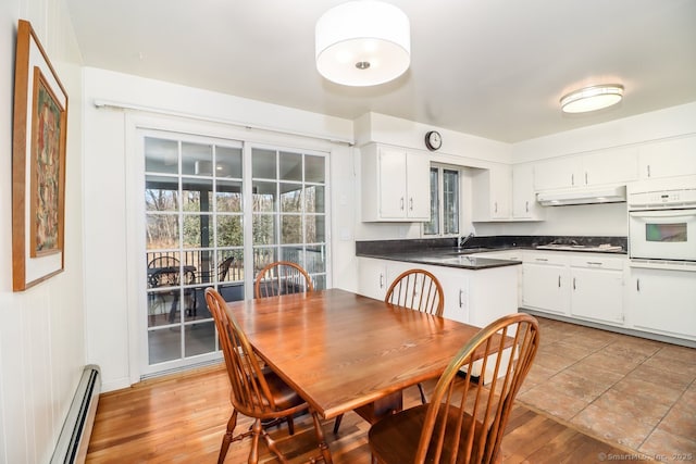 dining space featuring light wood-style floors and baseboard heating