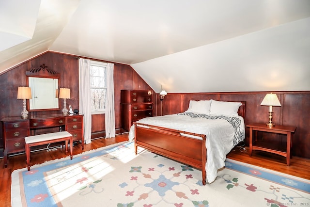 bedroom with lofted ceiling and wood finished floors