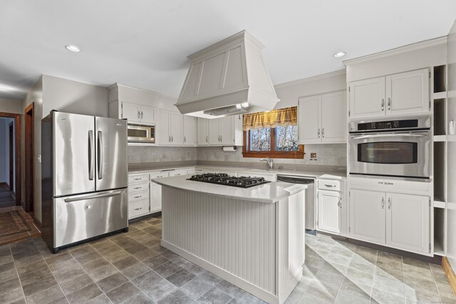 kitchen with appliances with stainless steel finishes, a sink, custom exhaust hood, light countertops, and backsplash