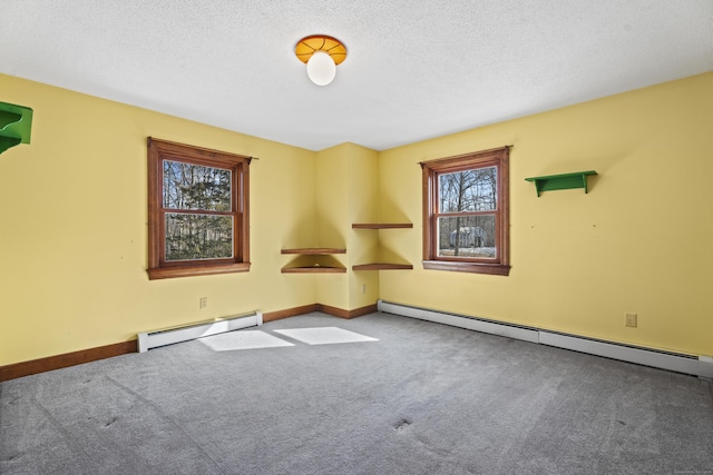 spare room with a textured ceiling, carpet floors, and baseboard heating